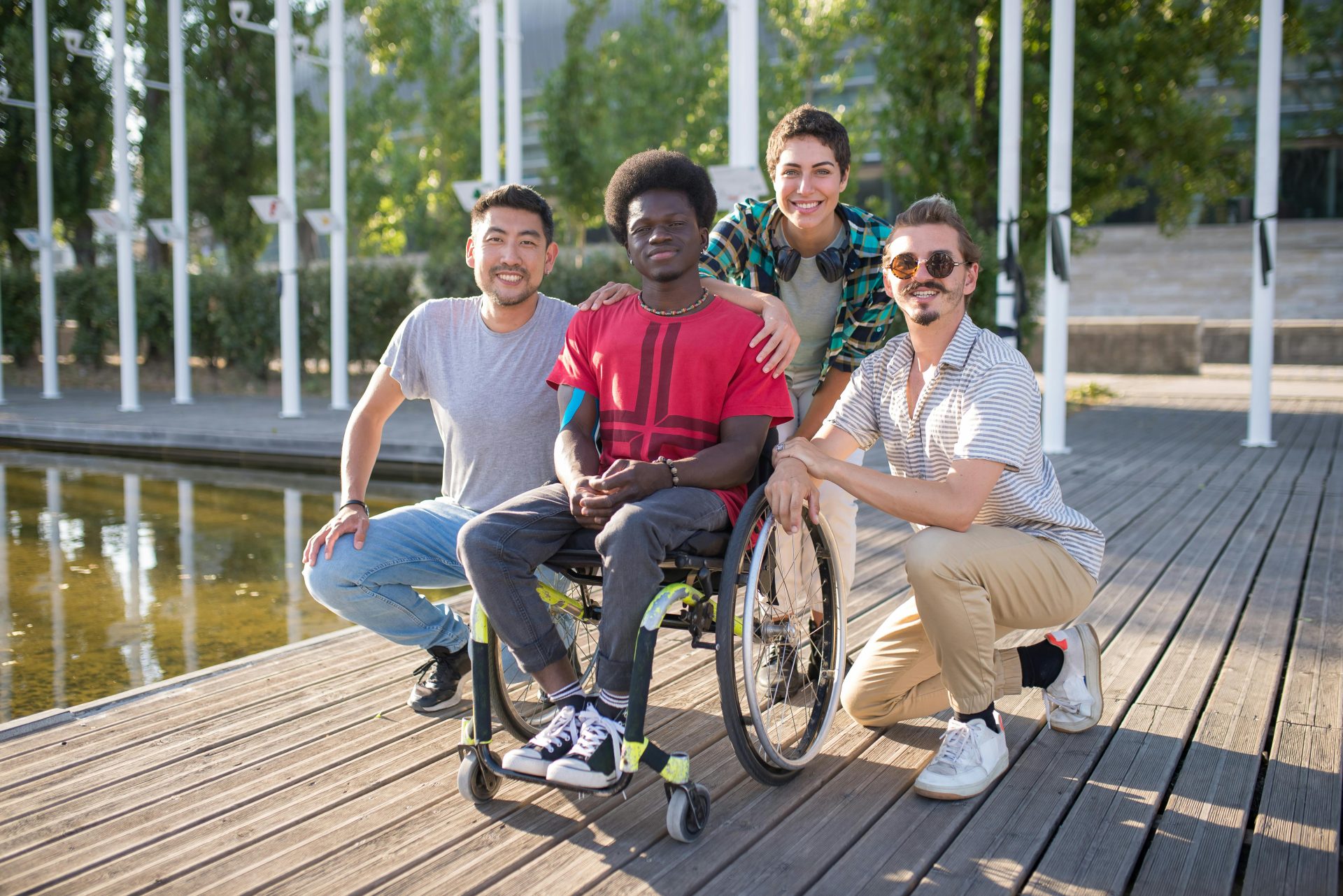 Young man in wheelchair surrounded by friends