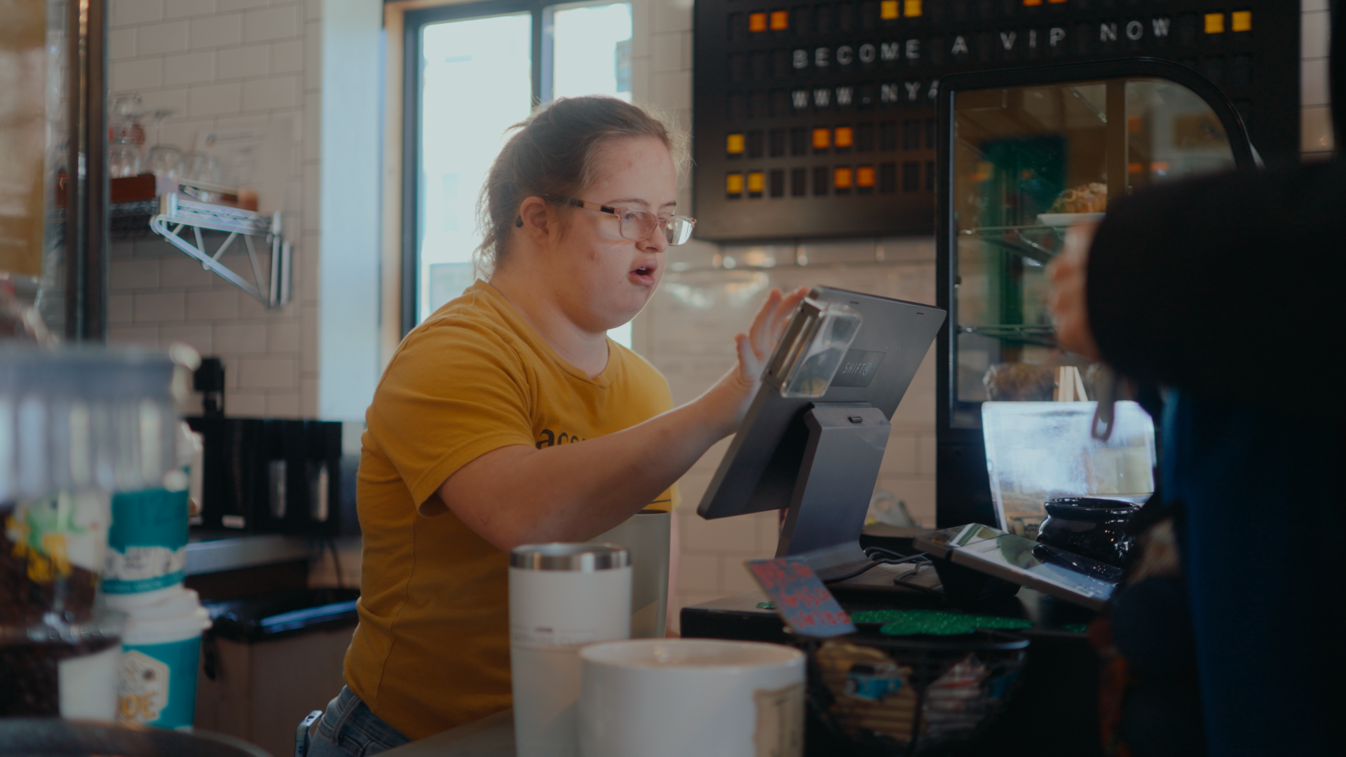 Female with Down Syndrome taking an order at a coffee shop